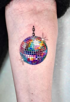 a colorful disco ball tattoo on the leg