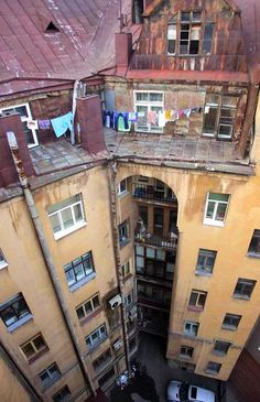 an aerial view of two buildings with cars parked in the street below and laundry hanging on clothesline to dry