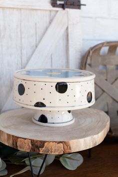 a white cake stand sitting on top of a wooden table