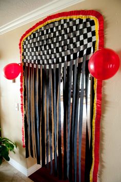 a room decorated with black, white and red ribbons on the front door for a race themed birthday party