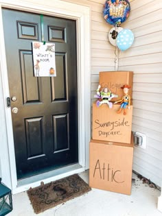 two cardboard boxes are stacked on top of each other in front of a door with balloons