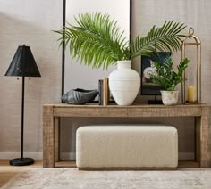 a living room with a bench, mirror and plants on the table in front of it