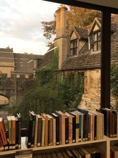 there is a bookshelf with many books on it in front of a window