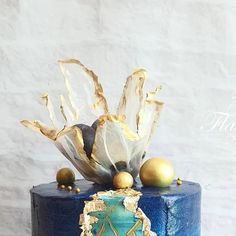 there is a blue cake with gold decorations on the top and bottom, along with other items