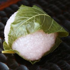 a piece of food that is on top of a table with some leafy leaves