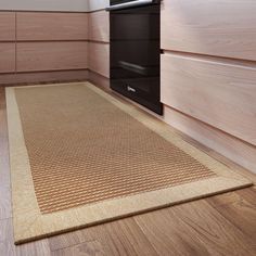 a kitchen with wooden cabinets and an area rug on the floor that has a stove in it