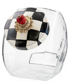 a black and white checkered glass vase with a red rose on the top, sitting in front of a white background