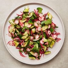 a white plate topped with radishes and other veggies on top of a table