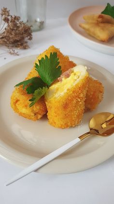 some food is on a white plate with gold spoons and silver utensils