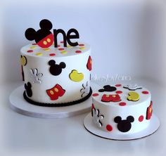 two mickey mouse themed birthday cakes sitting on top of each other