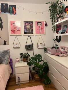 a bedroom with posters on the wall and a bed in the foreground, potted plant next to it