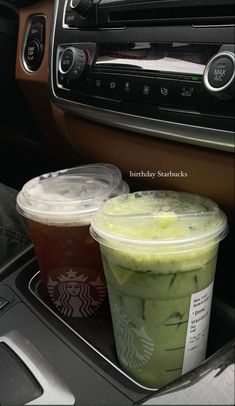 two starbucks drinks are sitting in the car