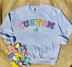 "Our Best Selling Custom Patch Sweatshirts are a Must Have! Customize with School Name/Mascot, Names, Initials, Sorority Names, & more!  Along with an array of colored Letters we also offer other shapes & designs too! Sports balls, Hearts, Smileys, Stars, & More!!  Make sure to swipe thru all the Listing Pics to see all the options we offer! HOW TO ORDER & CUSTOMIZE 1. Choose what SIZE you'd like from the pull down above 2. Choose how many patches you'd like on your Sweatshirt from the pull down above  3. Enter the Personalization you'd like on your sweatshirt along with the COLOR PATCHES AND THE COLOR SWEATSHIRT you'd like it to be in.  If you want multiple colors like pictured, enter what colors you'd like but please note the order of colors for the word will be a RANDOM pattern Example: Sorority Names, Farm Craft, Custom Patch, Yellow Smiley Face, Color Sweatshirt, School Sweatshirts