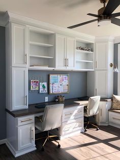 a home office with built in cabinets and desk