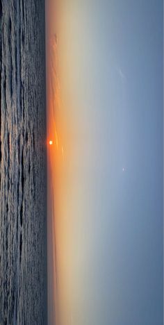 an airplane is flying over the ocean at sunset or sunrise with light coming from behind it