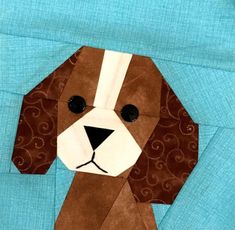 a brown and white dog made out of paper on top of a blue cloth background