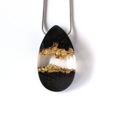 a black and white pendant with gold foil on it