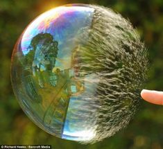 a person holding a soap bubble in their hand