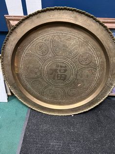 a large metal tray sitting on top of a floor next to a blue and white wall