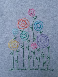 a t - shirt with flowers embroidered on the front and back, in multicolored thread