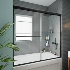 a white bath tub sitting under a window next to a sink and mirror in a bathroom