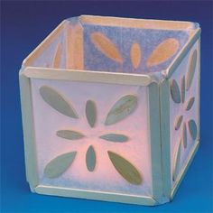 a white box with an intricate design on the front and sides, sitting on a blue surface