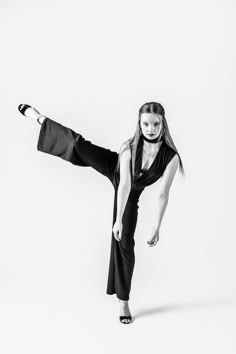 a woman in black and white poses with her legs spread out while wearing headphones