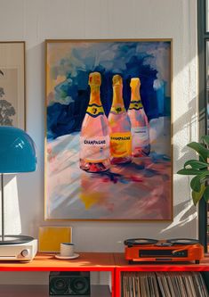 two bottles of champagne sitting on top of a wooden table next to a blue lamp