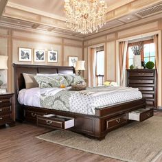 a bedroom with a bed, dressers and a chandelier