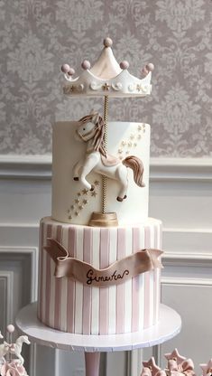 a three tiered cake with a carousel on top