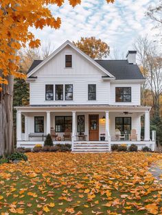 a white house surrounded by fall leaves