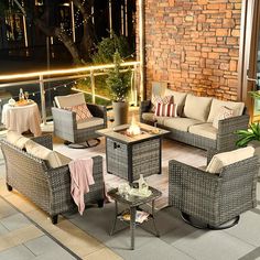 an outdoor living area with wicker furniture and lights on the balcony at night time