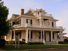 a large white house sitting on the side of a road