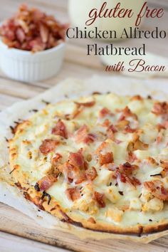 chicken alfredo flatbread with bacon on a cutting board next to a small white bowl