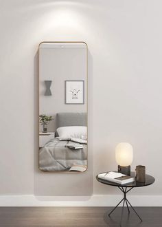 a white room with a large mirror on the wall next to a small side table