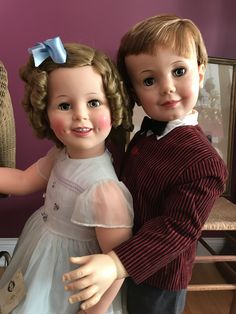 two dolls that are standing next to each other