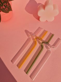 three glass candles sitting on top of a pink table