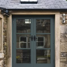 the front door to a stone building with two glass doors