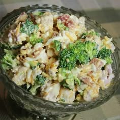 a glass bowl filled with broccoli salad on top of a checkered table cloth