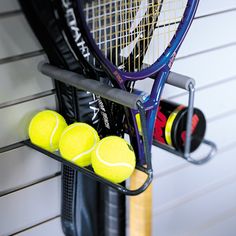 tennis rackets and balls are hanging on the wall