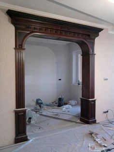 an arch in the middle of a room being worked on by a person with a paint roller