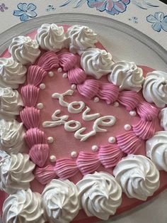 a heart shaped cake with white and pink frosting