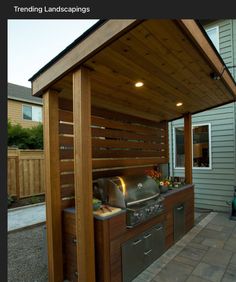 an outdoor kitchen is built into the side of a house with a grill and sink