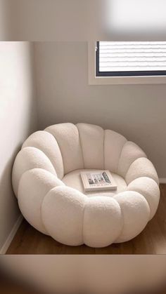 a white round chair sitting on top of a hard wood floor next to a window