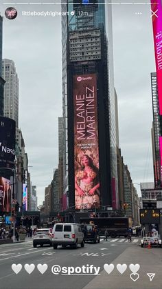 a city street filled with lots of traffic and tall buildings covered in billboards on the side of it