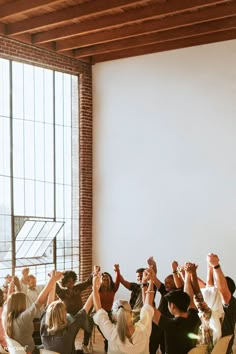 a group of people holding their hands up in the air