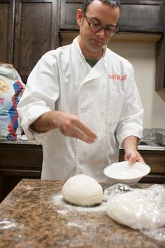 a man in a kitchen preparing food on top of a counter