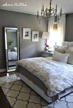 a bedroom with a bed, mirror and chandelier