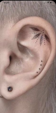 an ear with black dots on it and a small flower in the middle of the ear