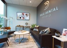 a living room filled with furniture next to a large glass window and a sign that reads billi dental studio